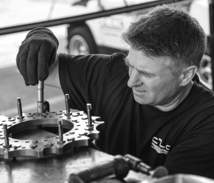 Maintenance technician inspecting industrial equipment on the plant floor, a common path to the maintenance manager role